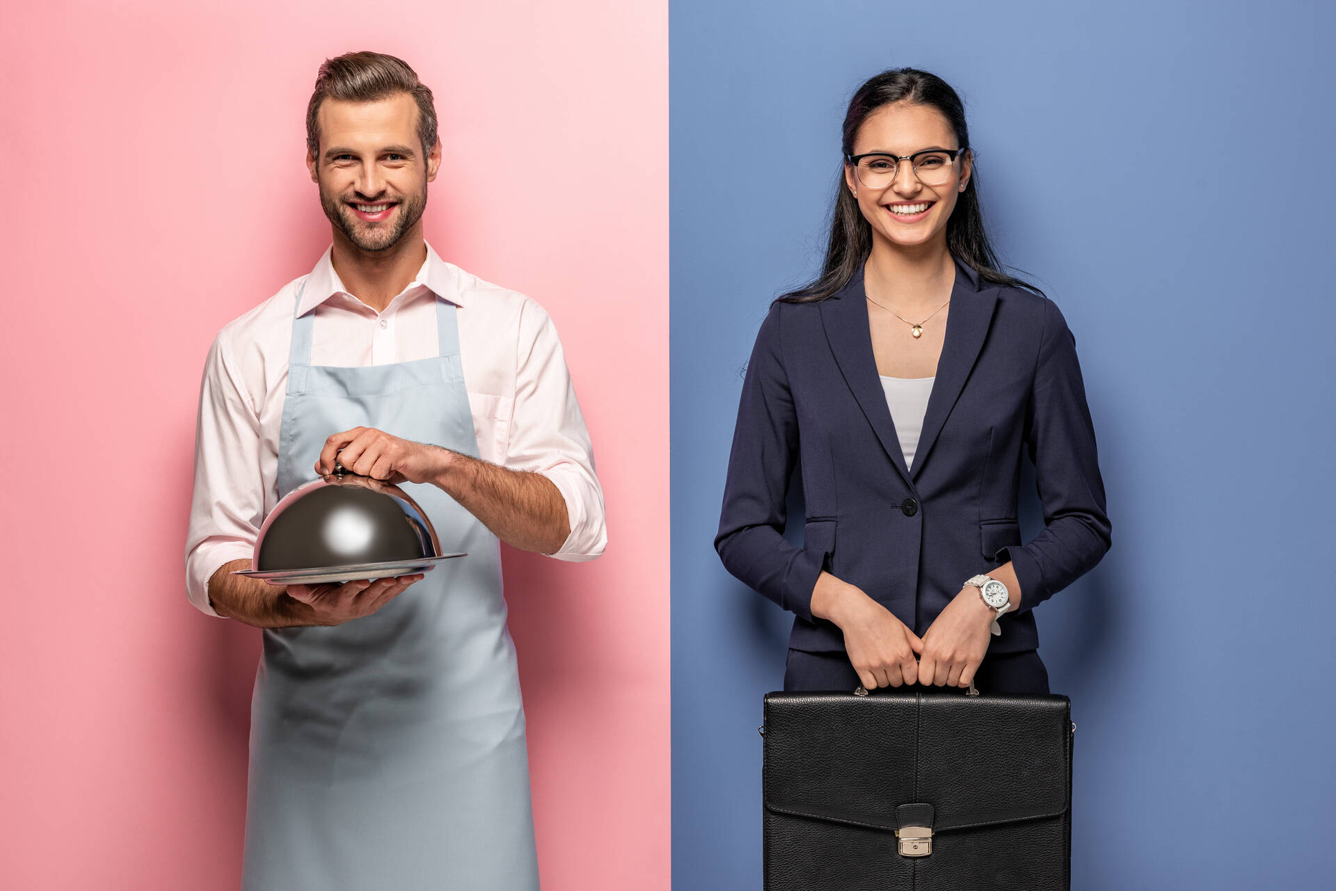 happy man in apron with Serving Tray and businesswoman with briefcase on blue and pink